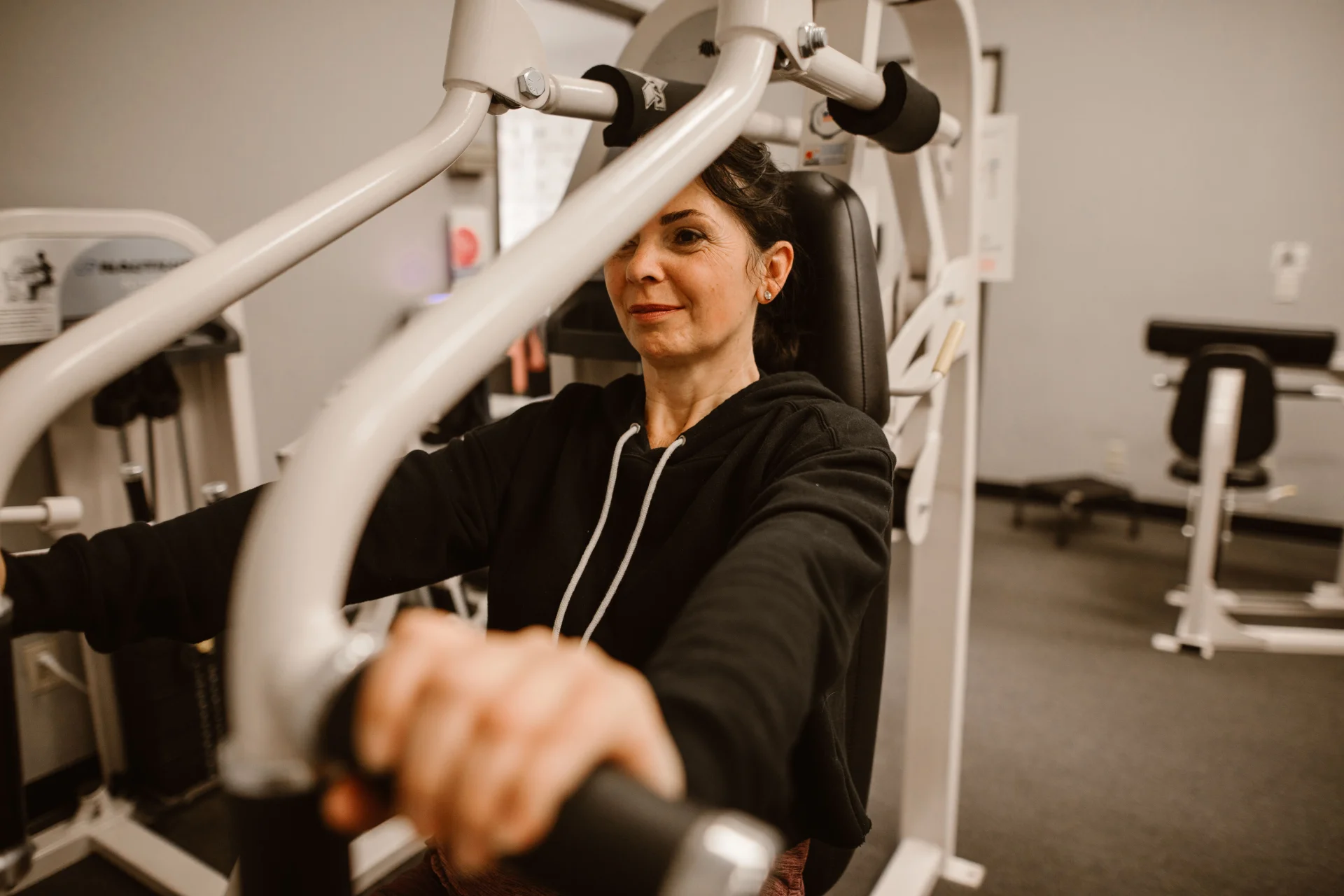 Kobieta skupiona na ćwiczeniach na sprzęcie do fitnessu, dbająca o zdrowy styl życia.